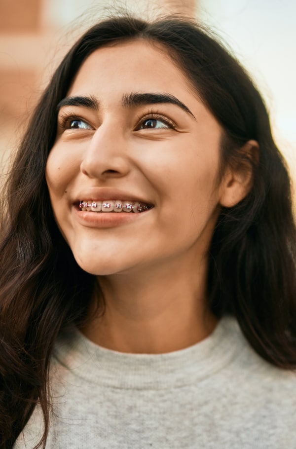 A girl is playfully smiling with her braces