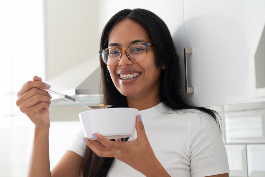 A girls is smiling while eating