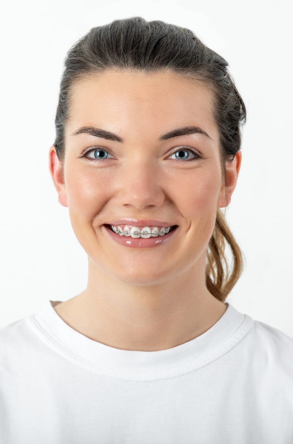 A boy in a yellow hat is joyfully smiling on the street