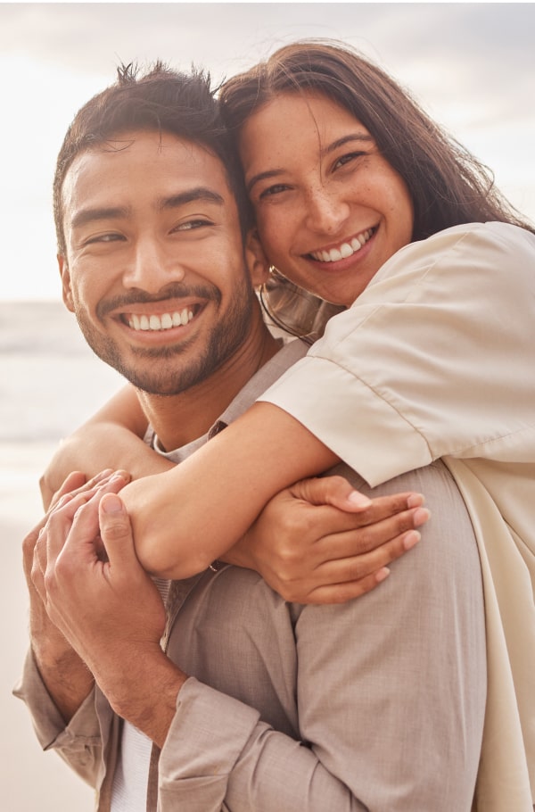 Couple is hugging and smiling on the beach