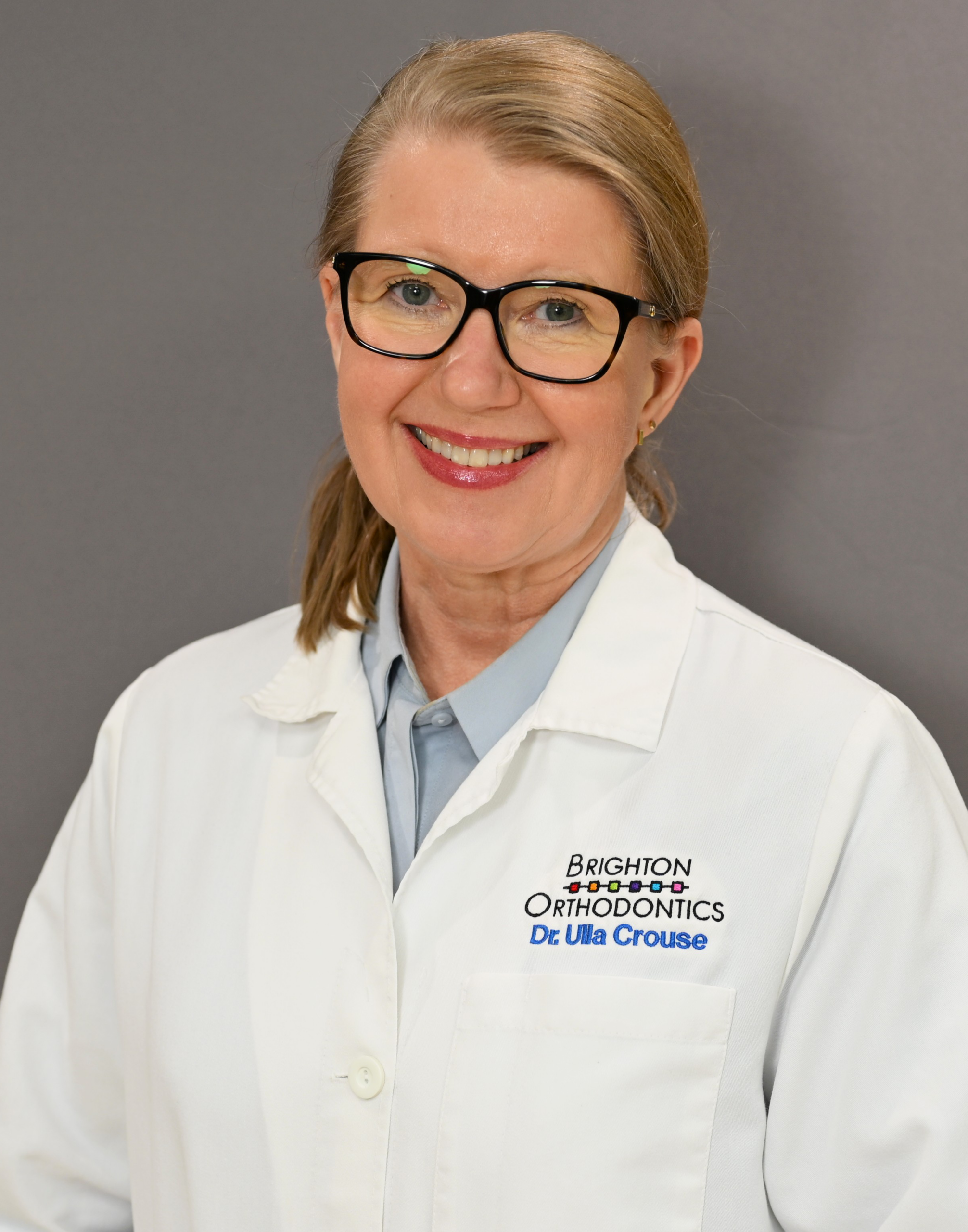 Dr. Ulla Crouse, dentist at Brighton Orthodontics, smiling warmly in her dental uniform
