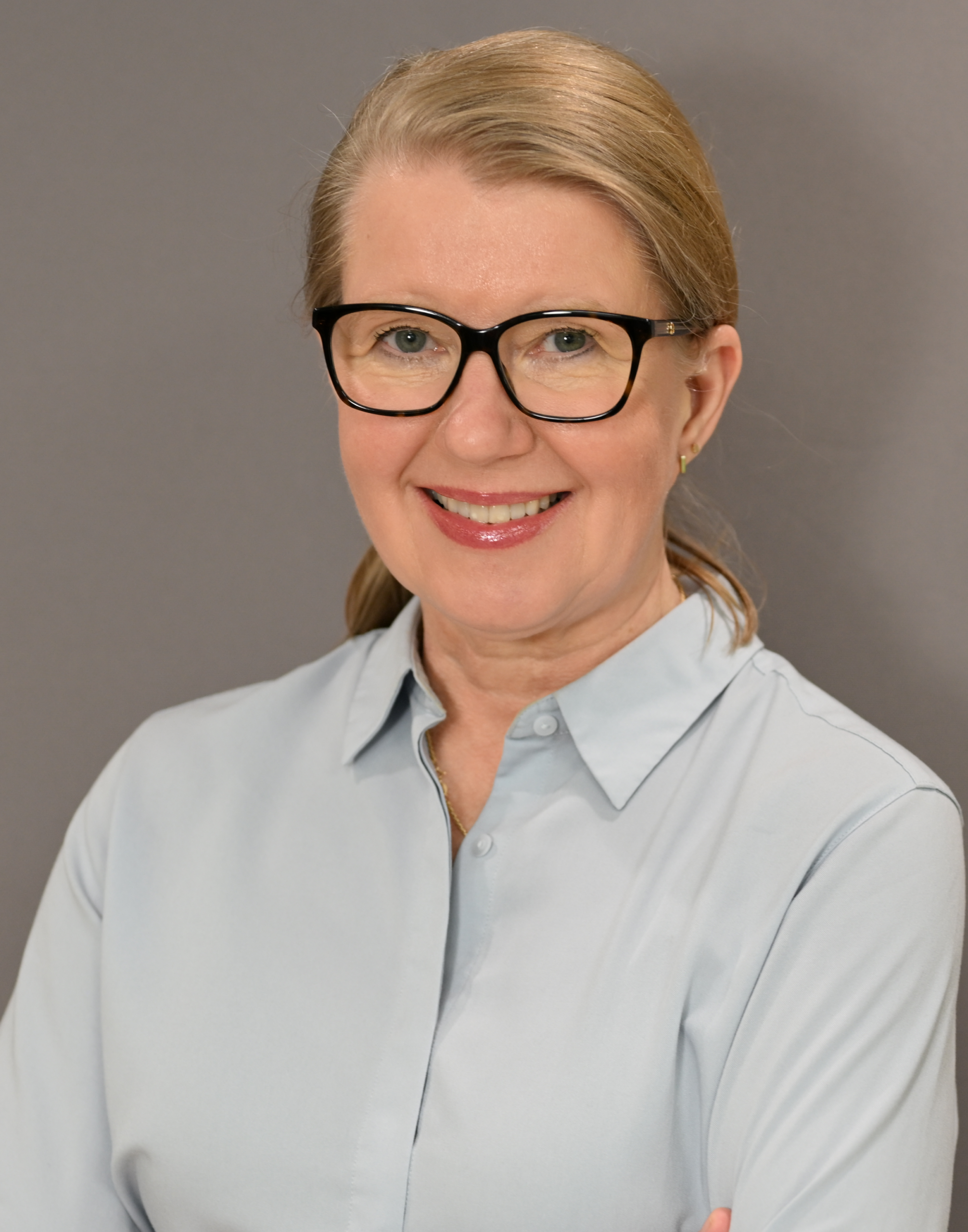 Dr. Ulla Crouse, dentist at Brighton Orthodontics, smiling warmly in her dental uniform